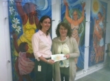 Ailbhe Ni Mhurchu, Business Process Analyst at Northern Trust presenting a donation to Majella Foley-Friel for ADAPT.